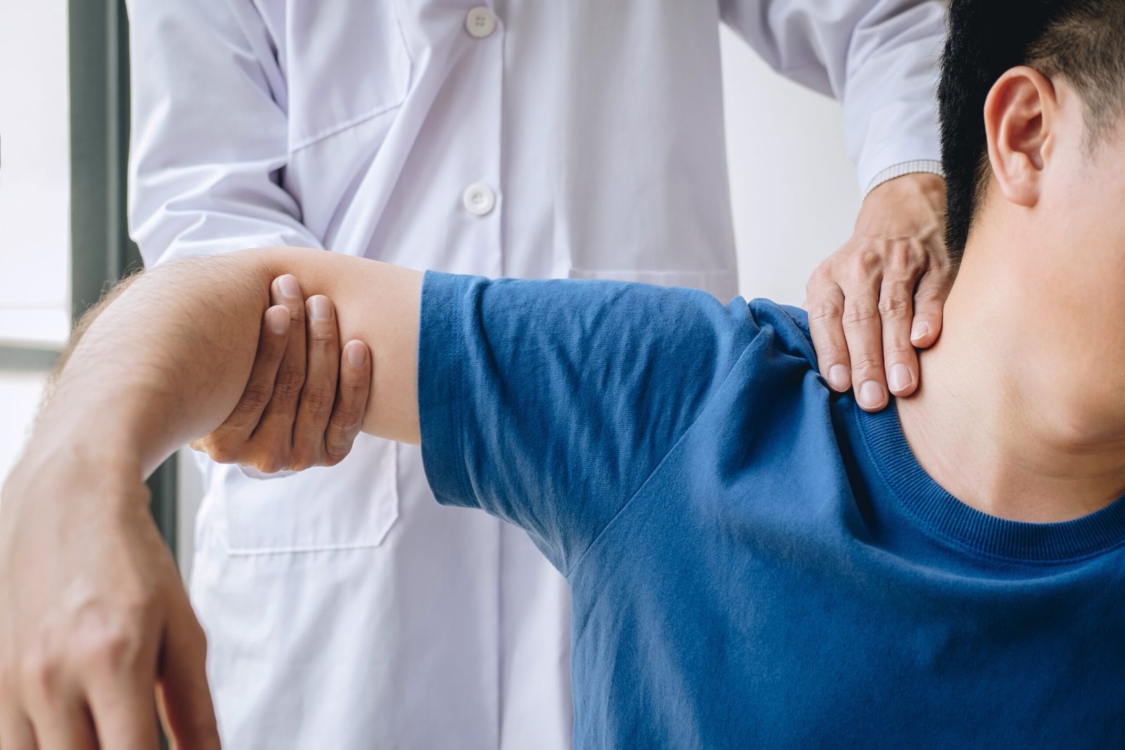 Doctor physiotherapist assisting a male patient while giving exe