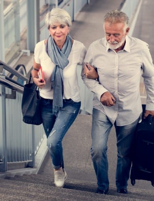 An elderly couple walking up the staircase
